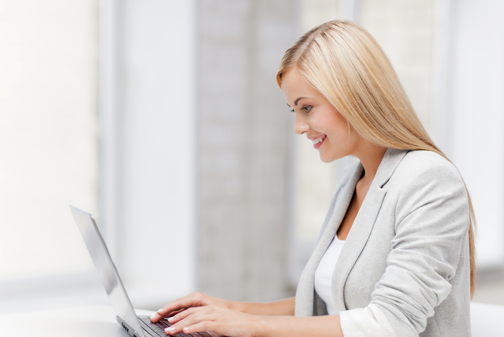 picture of smiling businesswoman using her laptop computer